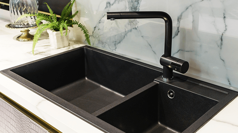 partitioned black kitchen sink and faucet