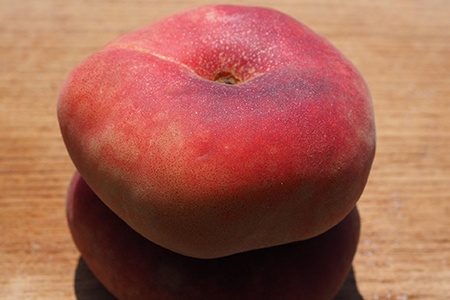 some varieties of peach, like donut peaches, have a flat shape